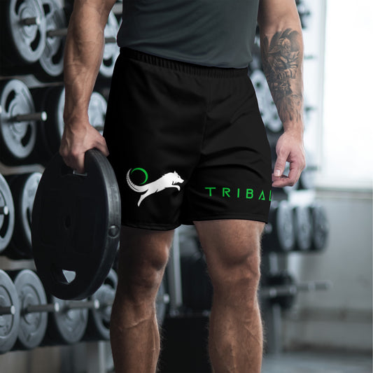 Man wearing black Tribal shorts in a gym while carrying a weight.